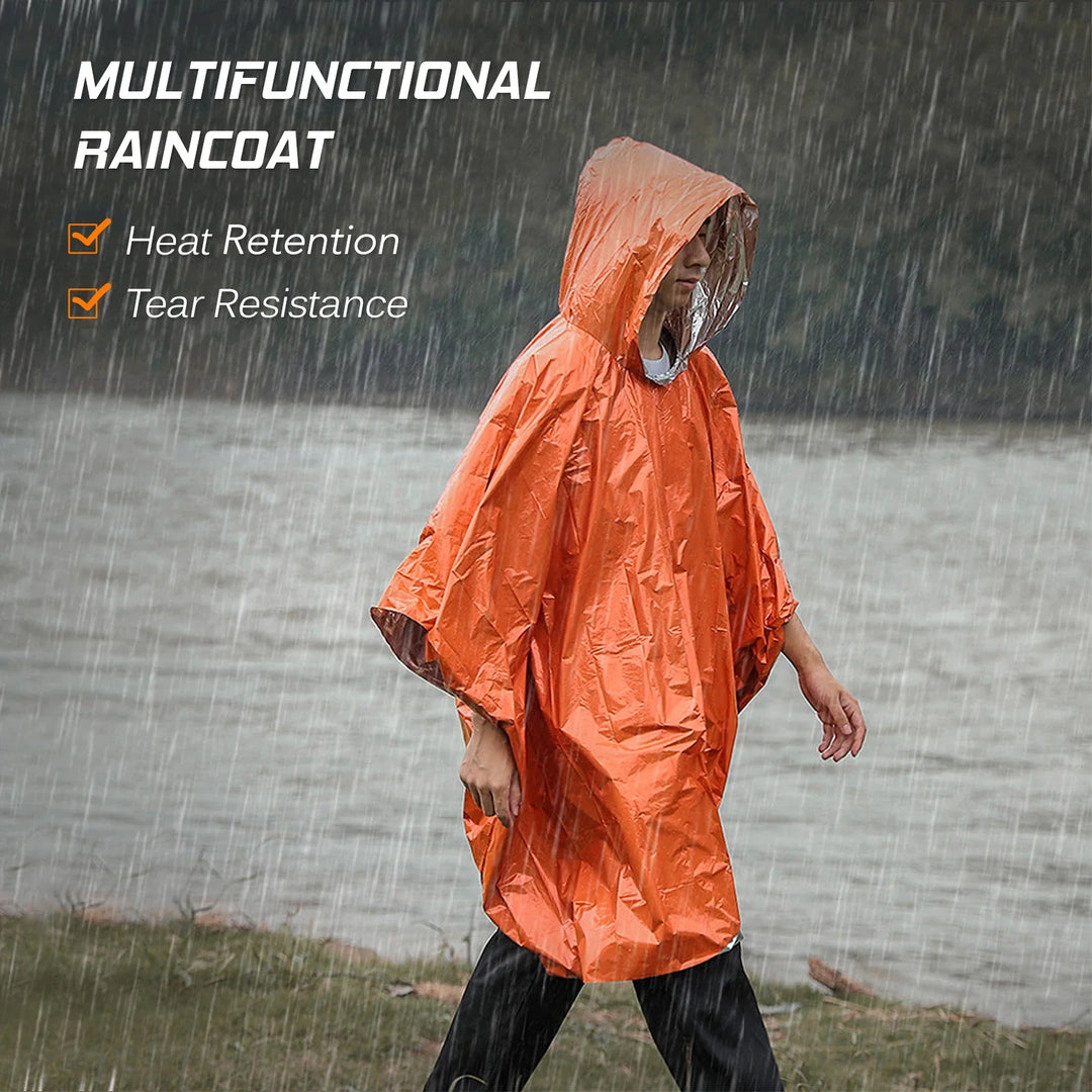 Person wearing a silver emergency thermal poncho in rain, clearly showing waterproof material