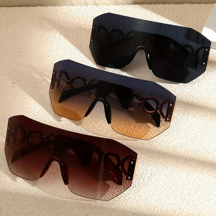 Close-up of futuristic frameless sunglasses with shiny gold temples & gradient lenses. Provides UV400 protection.