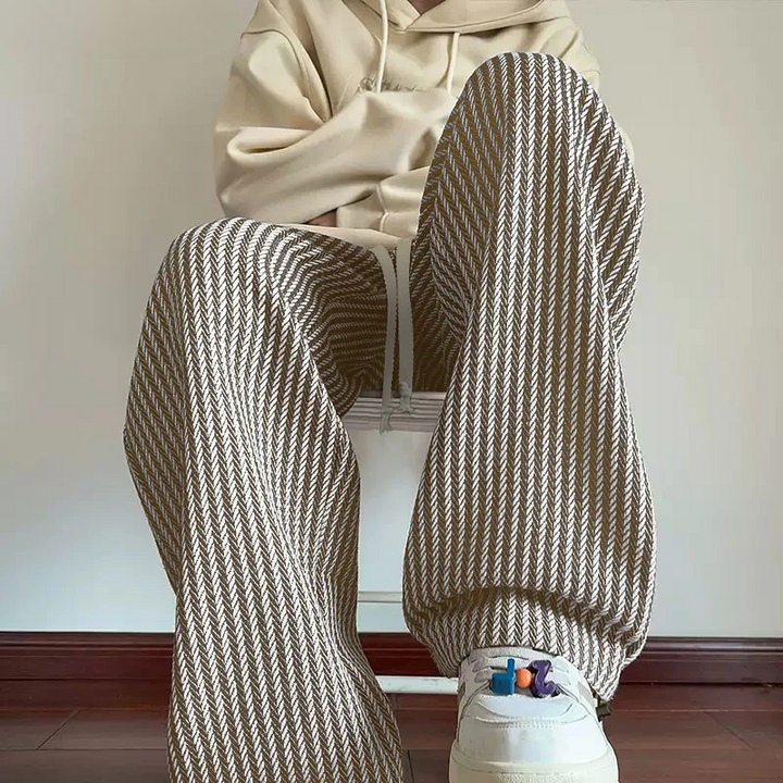Black unisex herringbone sweatpants, relaxed wide leg with drawstring waist & practical side pockets.