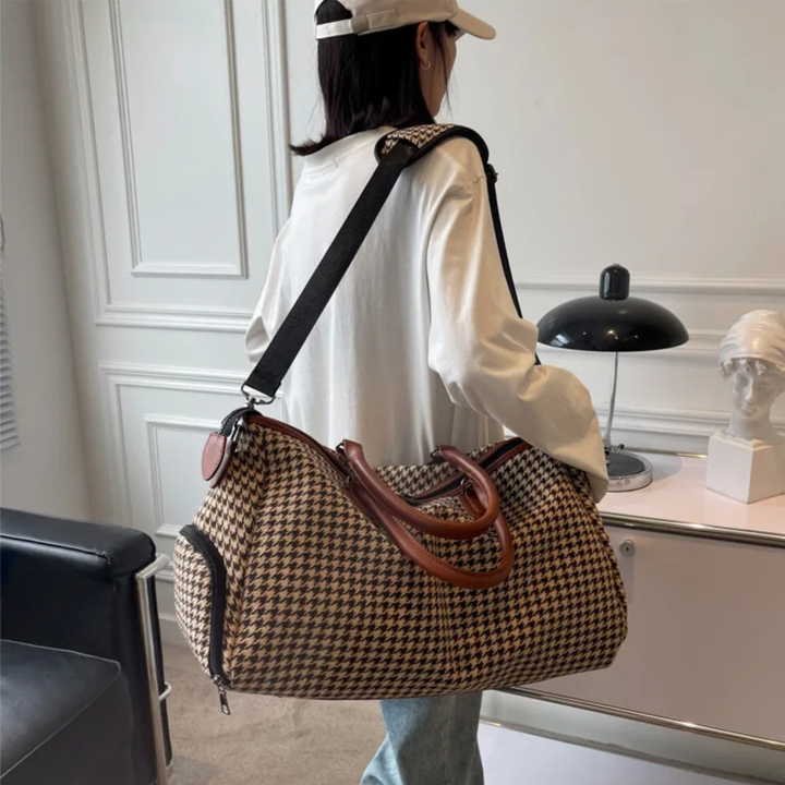 Durable houndstooth weekender bag, side view. Vegan leather travel duffle, unisex carry-on for short trips.