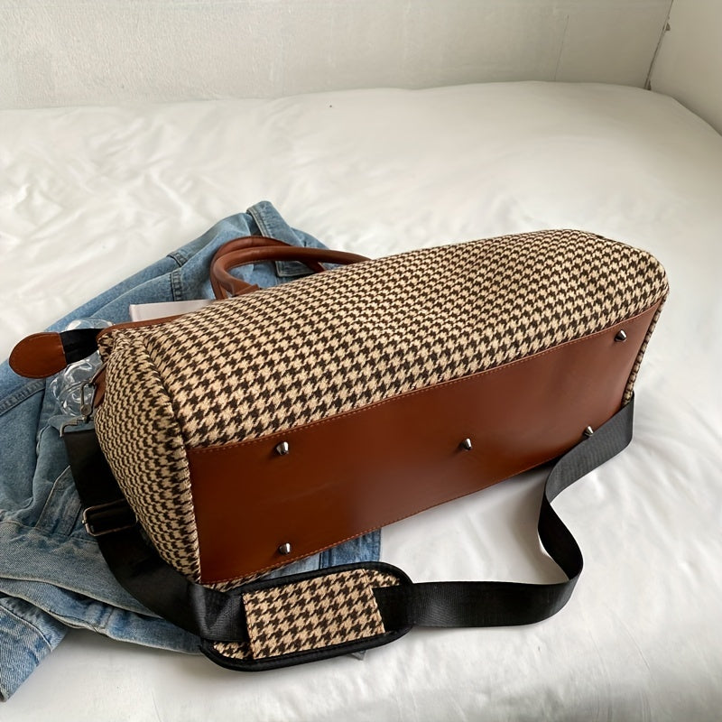 Unisex houndstooth weekender bag carried by a traveler. Stylish vegan leather duffle, perfect carry-on.