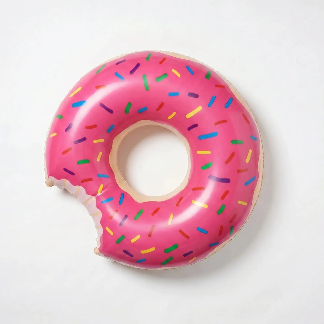 Friends relaxing on a giant inflatable donut pool float, enjoying summer fun in a sunny pool.