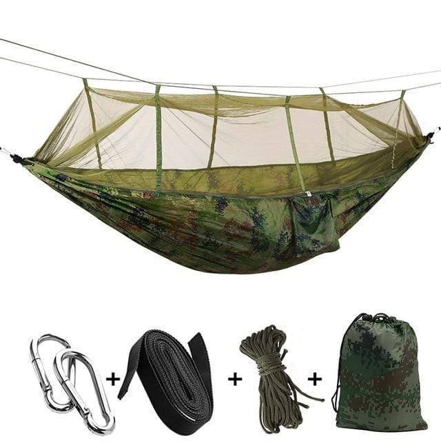 Unisex outdoor camping hammock set up between trees with its mosquito net, ready for use.