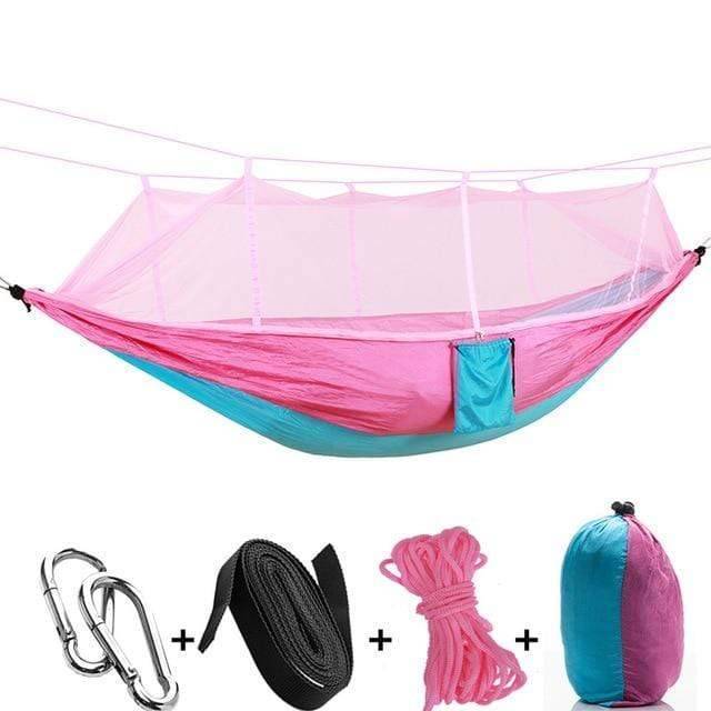 Folding camping hammock with a protective mosquito net, perfect for serene outdoor relaxation.