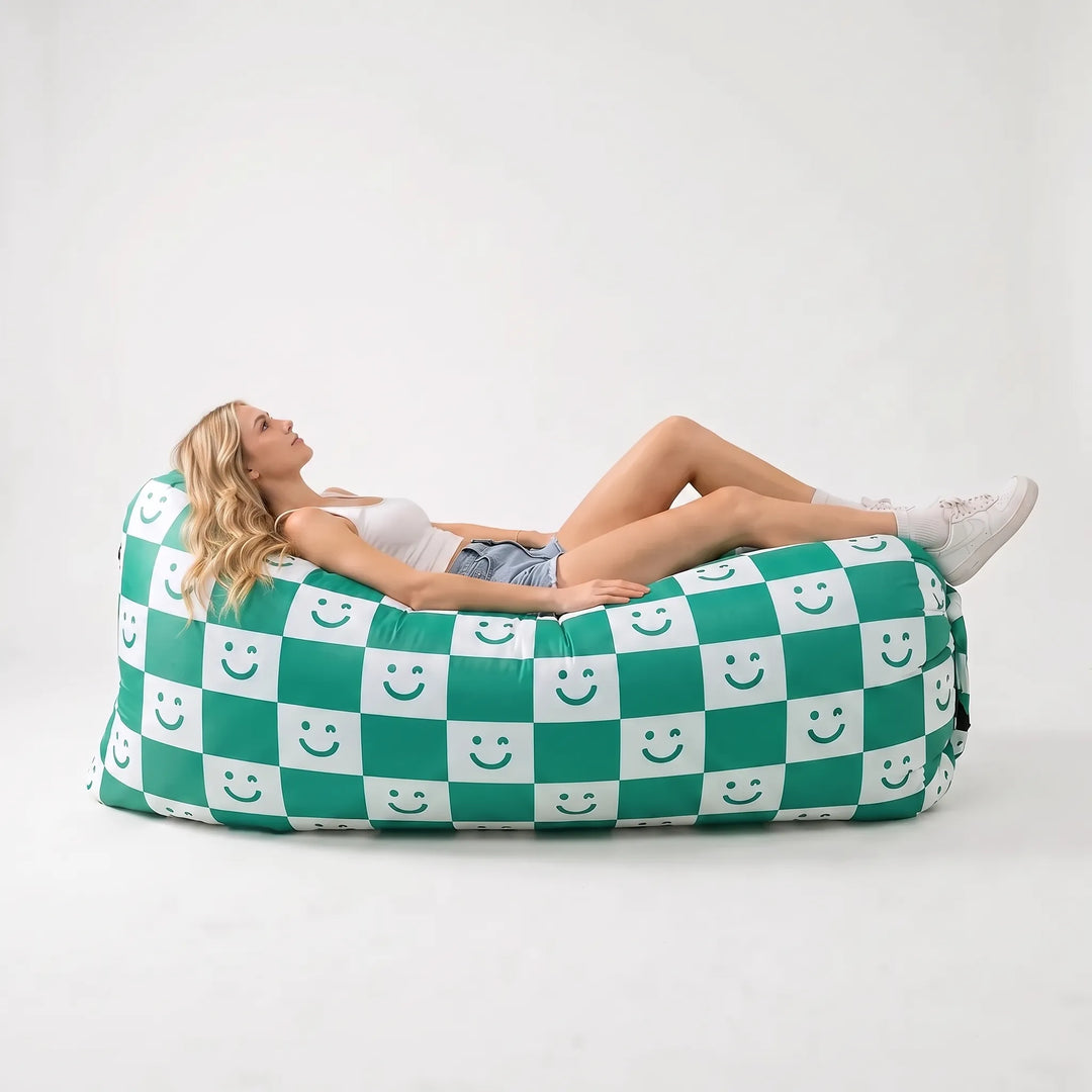 Inflatable air couch on a beach, perfect for sunbathing or relaxing at festivals. Portable, comfortable outdoor seating.