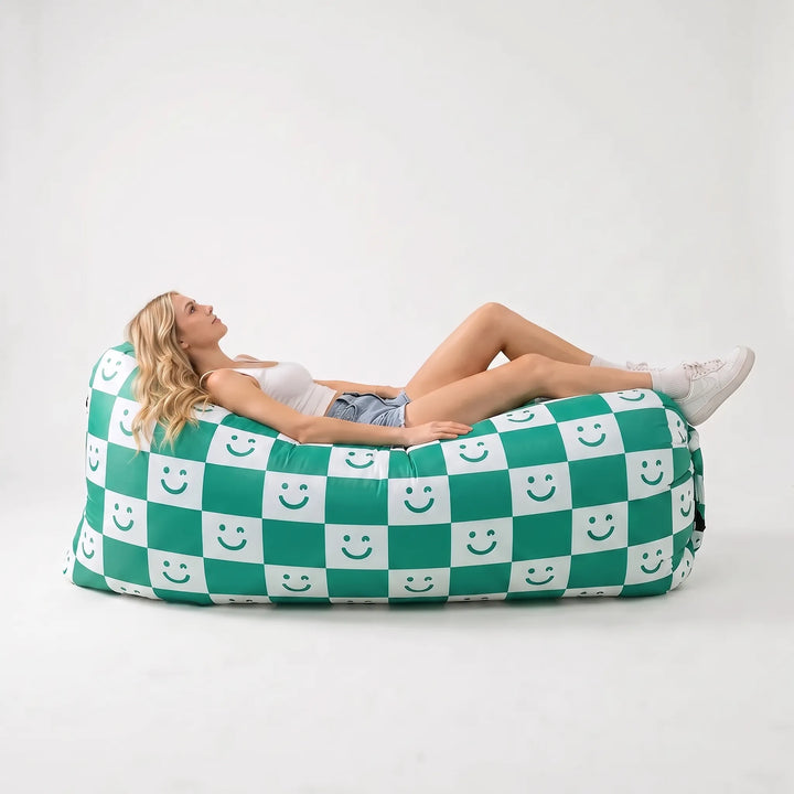 Inflatable air couch on a beach, perfect for sunbathing or relaxing at festivals. Portable, comfortable outdoor seating.