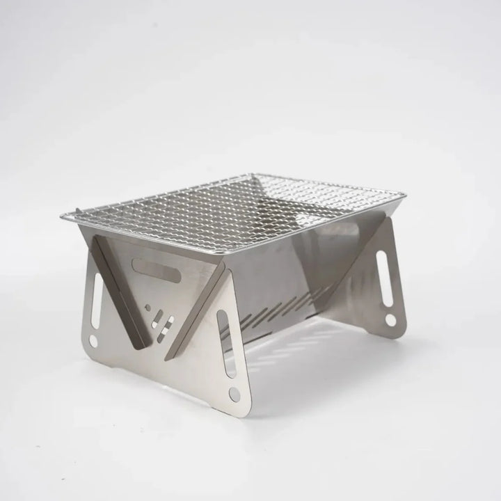 Side view of the unfolded stainless steel camping grill, showing its sturdy design for outdoor use.