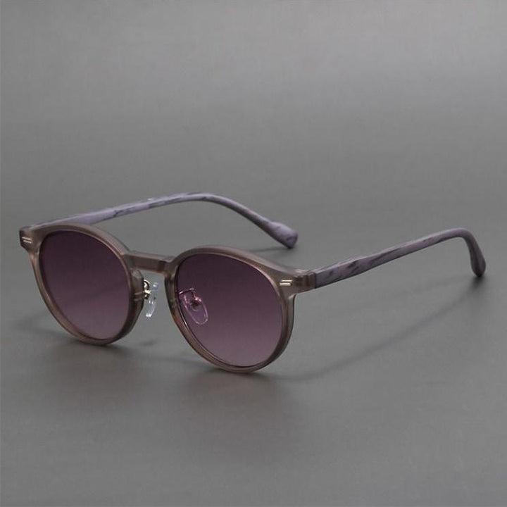 Purple round lenses in stylish unisex sunglasses. Trendy eyewear offers essential UV protection.