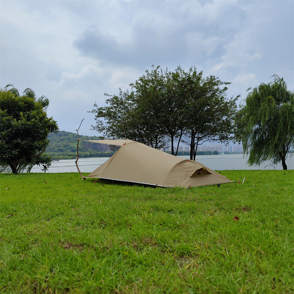 Unisex ultralight 1-person tent set up by a lake, offering a serene solo camping experience.