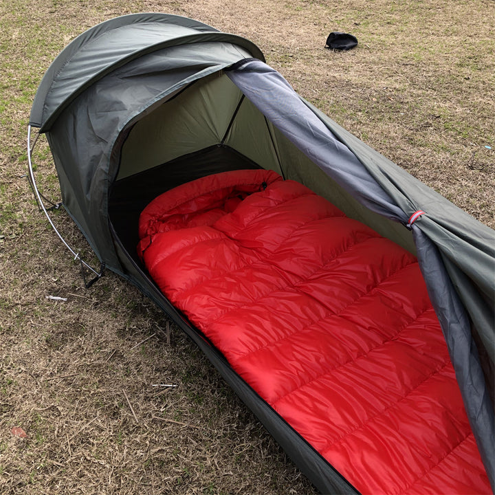 Unisex backpacking bivy tent packed into its stuff sack, showcasing its compact size.