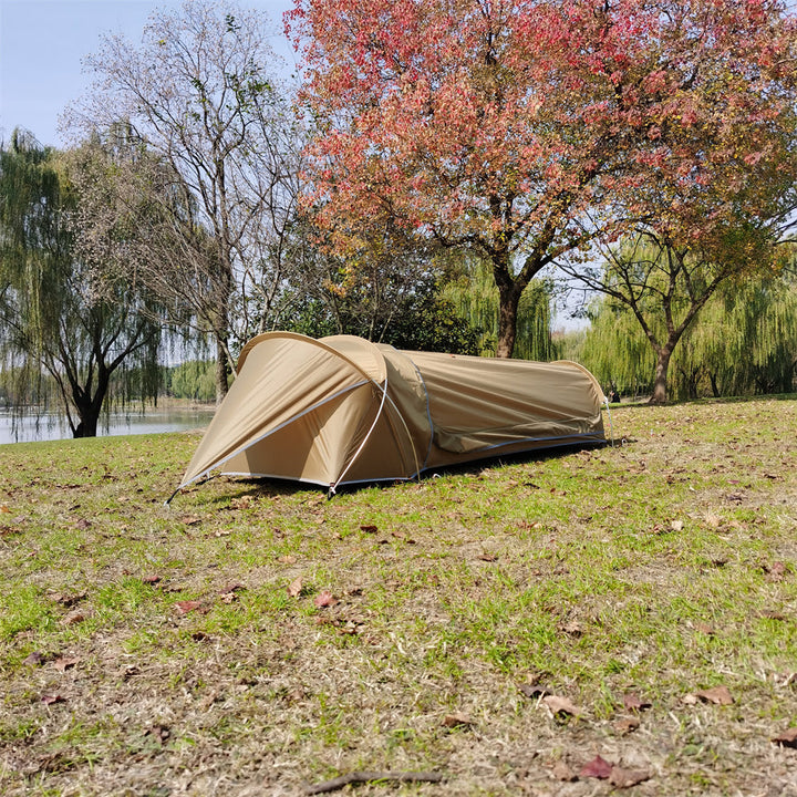 A person emerging from the single person backpacking bivy tent, demonstrating scale.