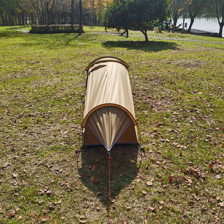 Ultralight 1kg bivy tent shelter pitched in a forest, blending with the outdoor environment.