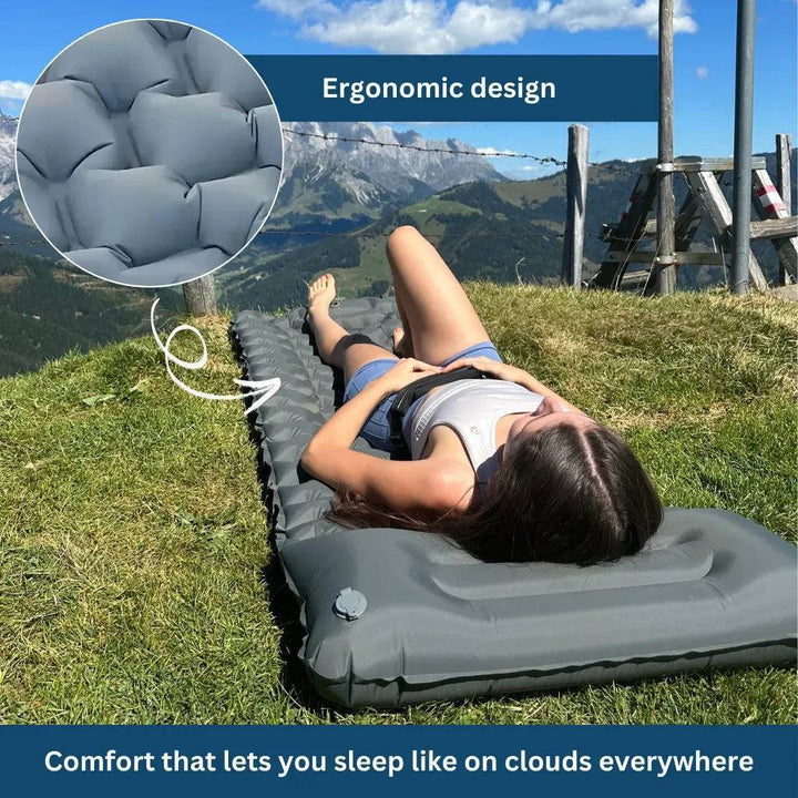 Unisex ultralight inflatable camping mattress with built-in pump, blue, side view, on outdoor ground