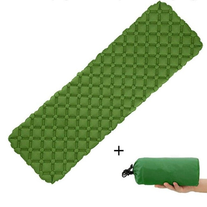 Portable sleeping pad next to a backpack, emphasizing its compact size for travel and hiking.