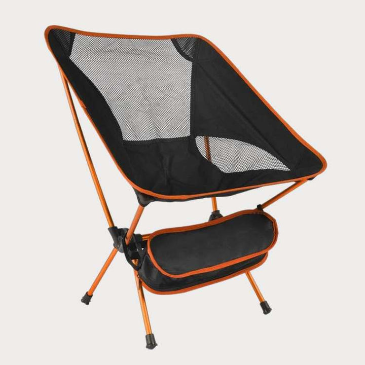 Unisex ultralight portable folding camp chair in black, unfolded on green grass, ideal for camping and hiking.