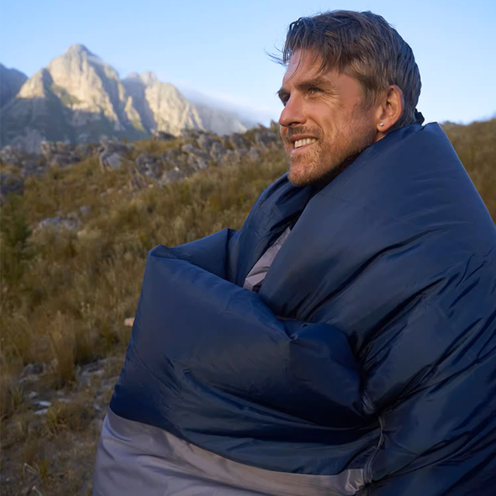 Portable camping sleeping bag with its carry bag, ready for a travel adventure