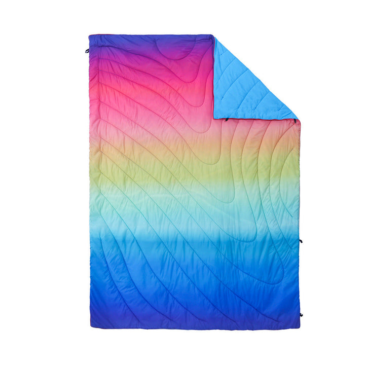 Outdoor enthusiast using the camping blanket as a windbreak.