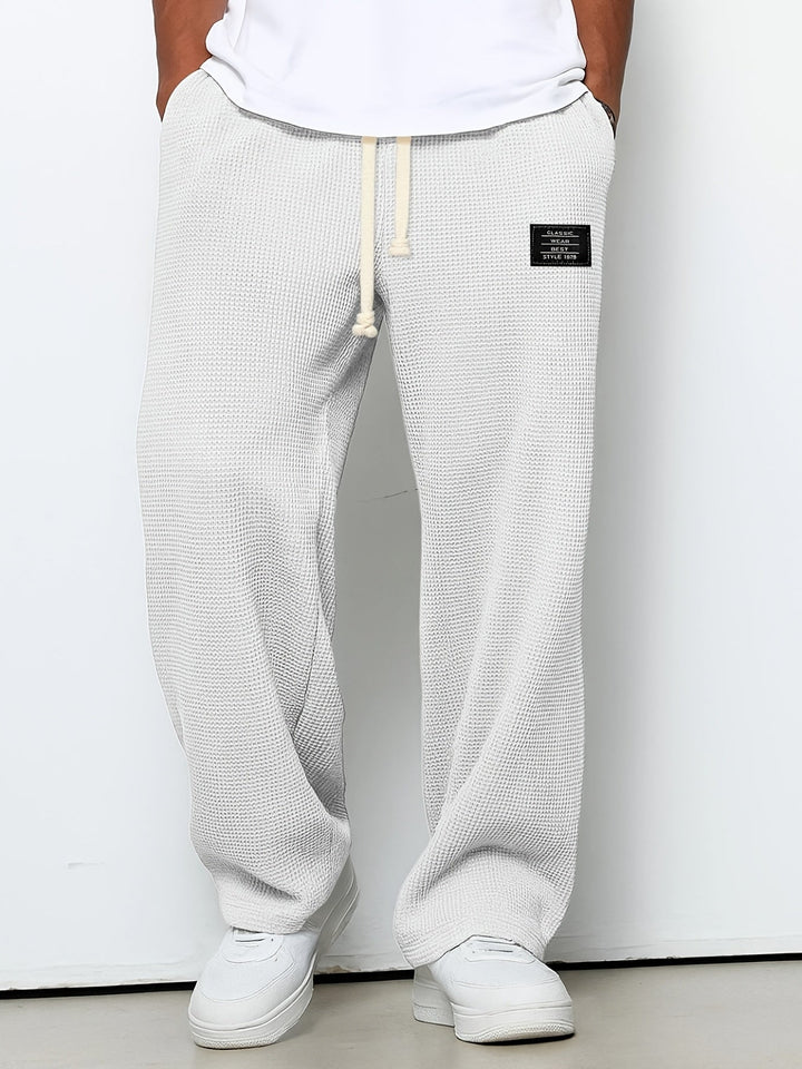 Soft waffle knit relaxed lounge pants for unisex comfort. Casual, wide-leg design with an adjustable drawstring.