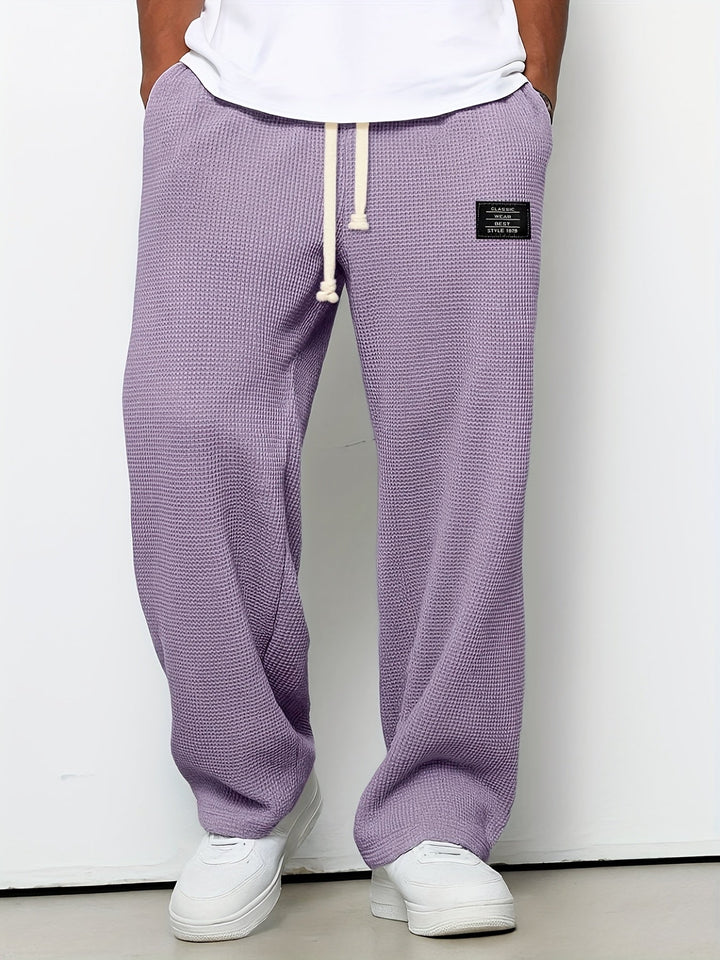 Waffle knit unisex lounge pants, relaxed fit with a drawstring. Soft, wide-leg comfort wear for casual style.
