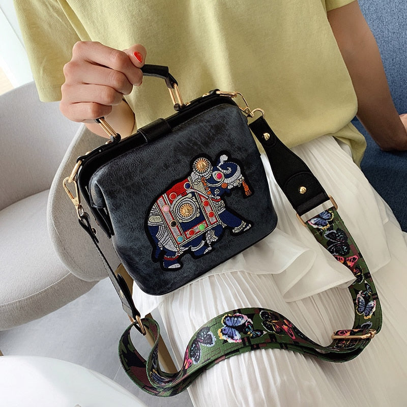 Close-up of detailed mandala embroidery on a bohemian shoulder bag accessory.