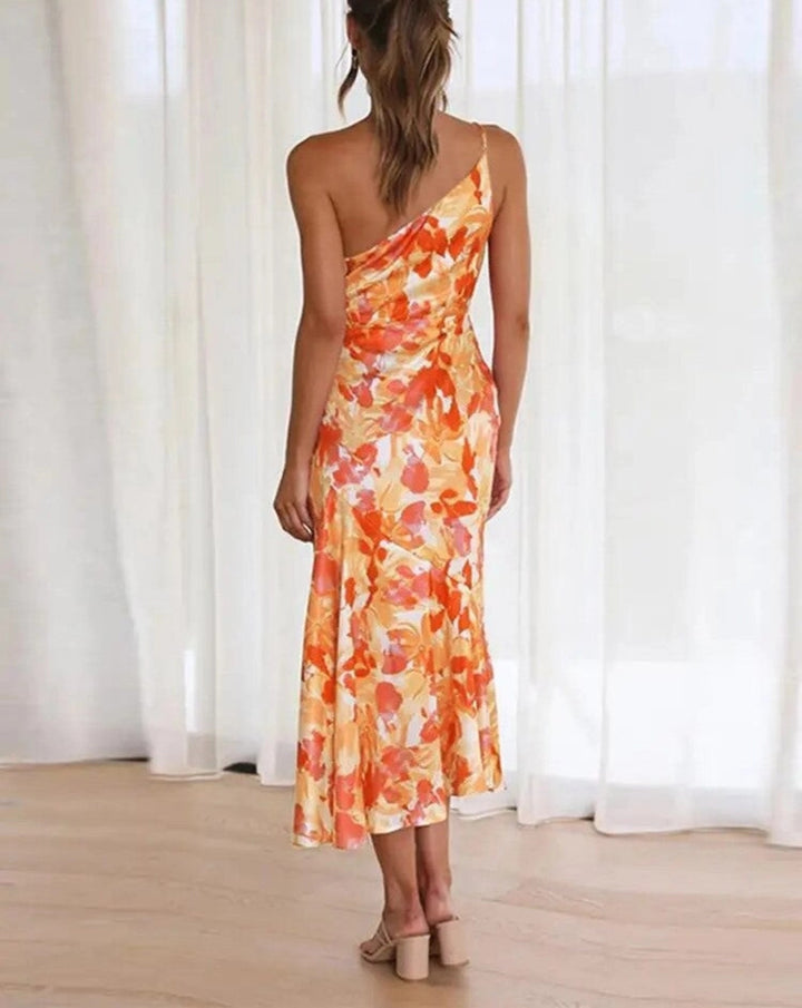 Vibrant women's summer midi dress, floral print, sleeveless, asymmetric flowing hem, trendy occasion wear.