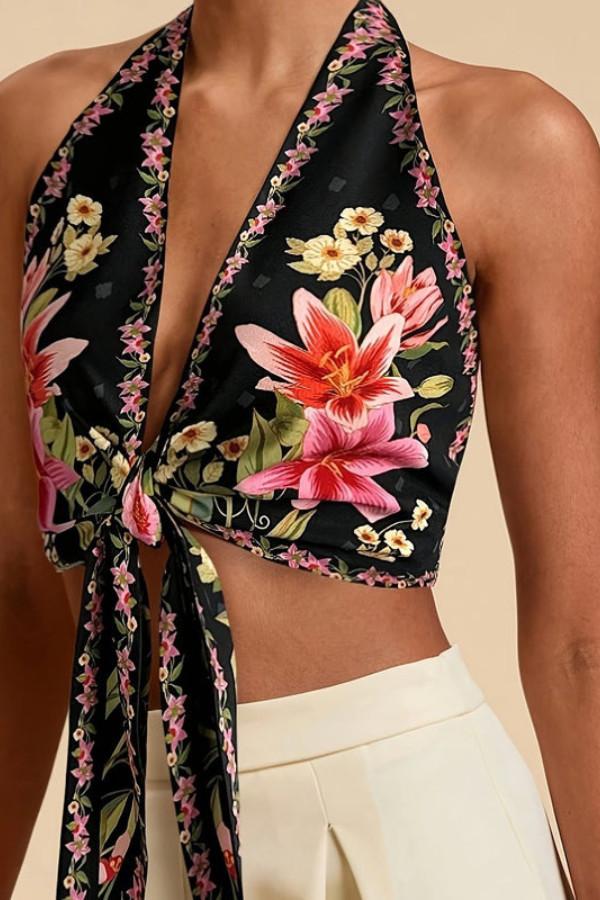 Close-up of vibrant floral print on women's halter top, showcasing summer fashion details.