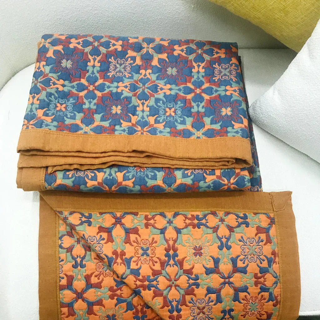 Vibrant orange & blue patterned six-layer cotton quilt. Reversible duvet for cozy, modern home textiles.