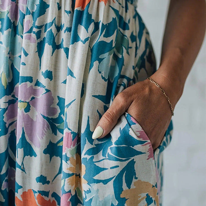 Stylish women's floral maxi dress. Smocked for comfort, sleeveless summer fashion with a vibrant print & ruffled hem.