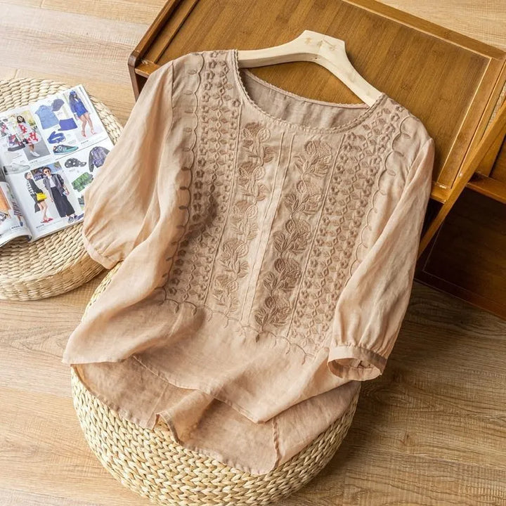 Beautiful women's Annelise blouse with floral embroidery, elegant puff sleeves, and a flattering high-low hem design.