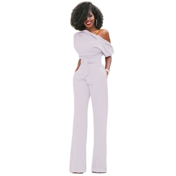 Model wears an elegant asymmetrical one-shoulder jumpsuit, showcasing its modern style and flowing wide-leg design.