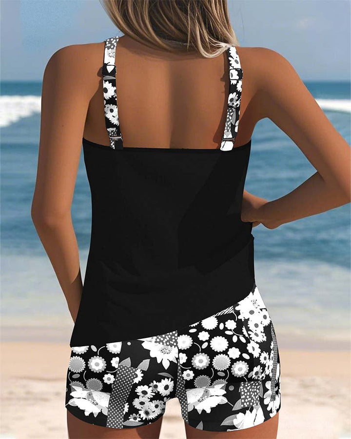 Confident women's floral tankini swim set. Belly-covering top & sporty swim shorts, perfect for summer.