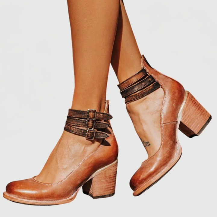 Close-up of women's buckle strap ankle boots showcasing the elegant cutout design and block heel.