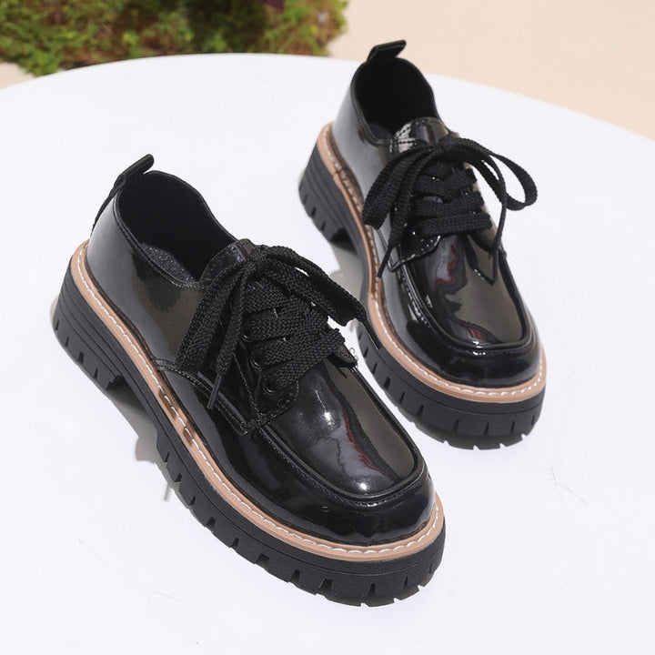 Side view of women's black chunky platform loafers, showcasing the thick sole and slip-on design.