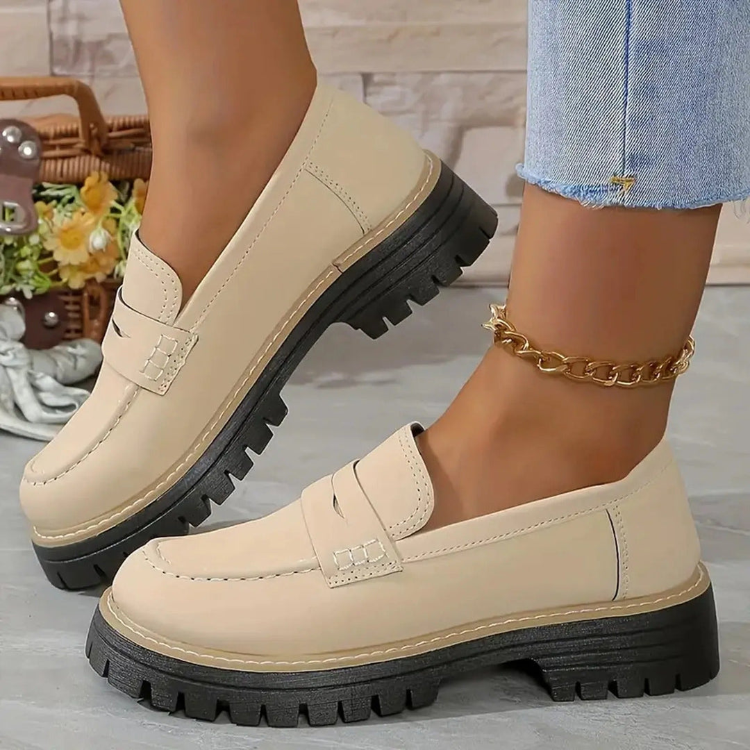 Women's black chunky platform loafers with a prominent lug sole, perfect for stylish casual or office wear.