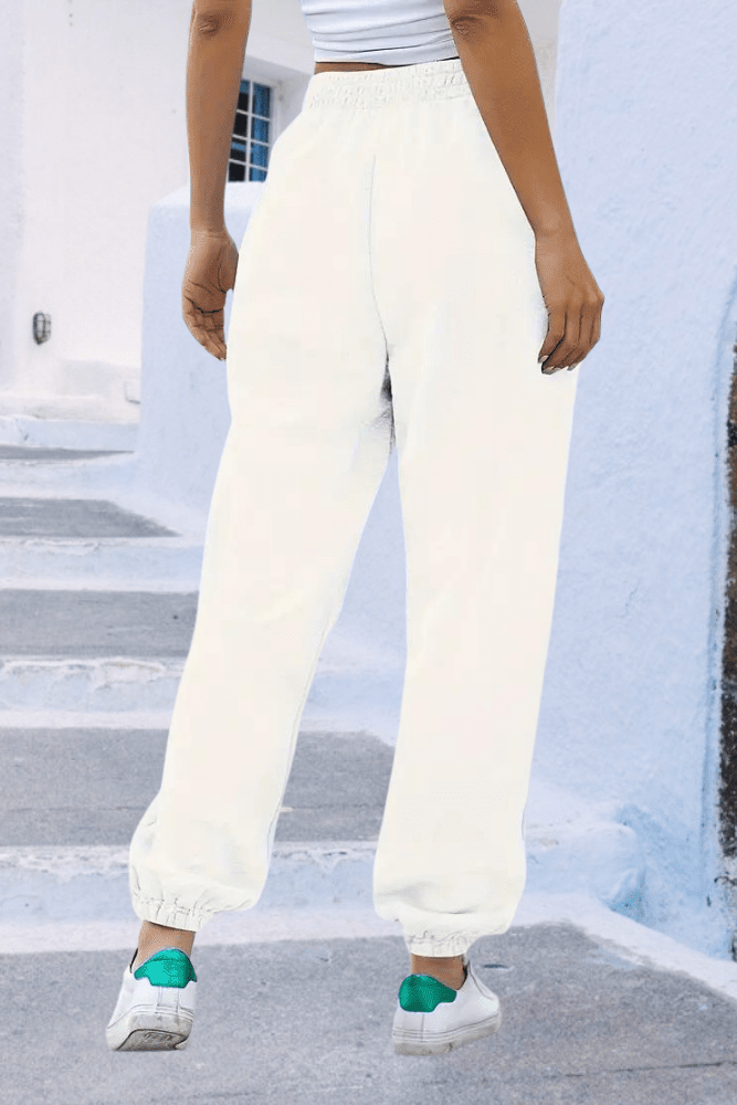 Close-up: soft fabric women's high-rise joggers, elastic waistband & drawstring detail.