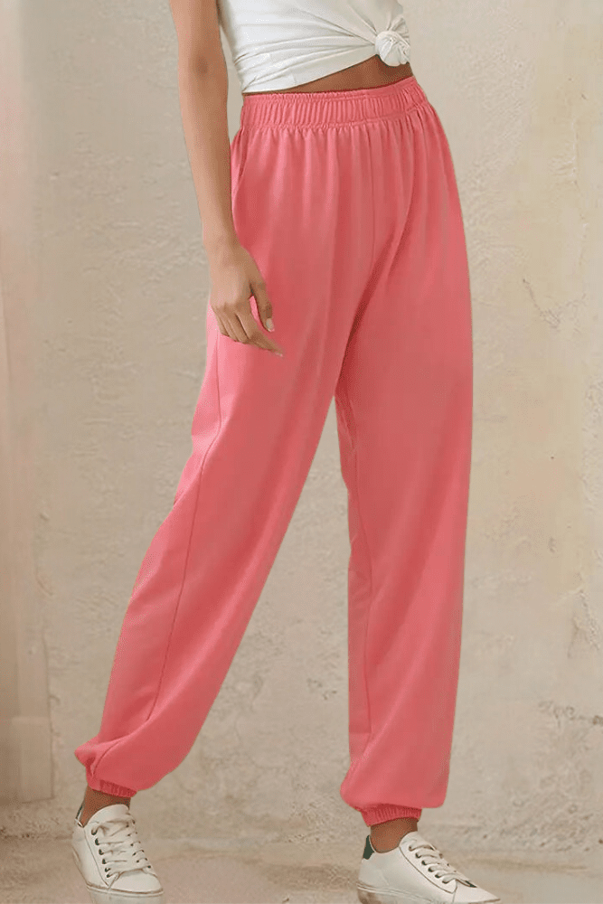 Folded women's black high-rise joggers, highlighting elastic waist, soft touch material.