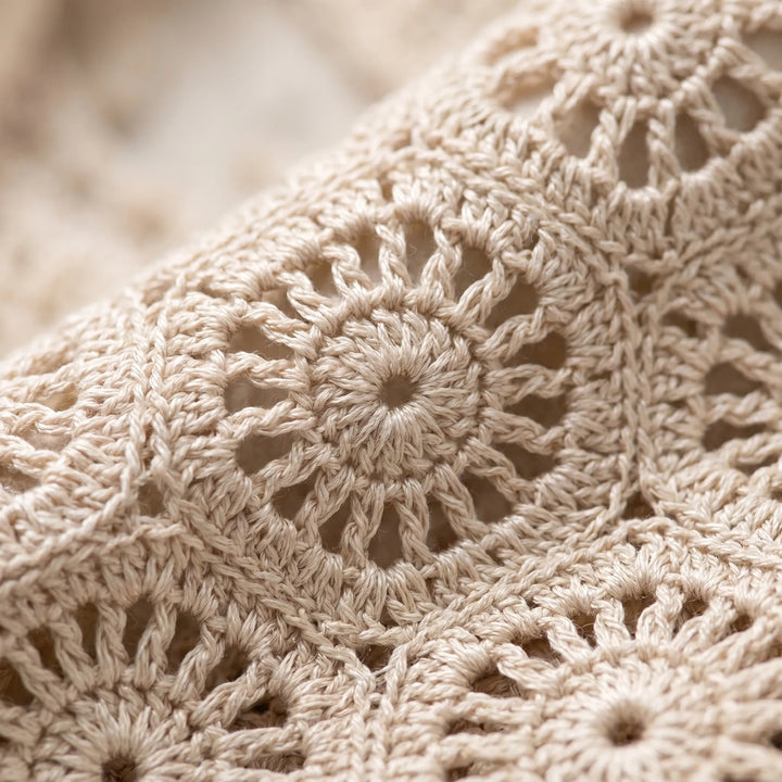 White bohemian crochet crop top for women. Stylish sleeveless summer top with relaxed fit, great for festivals.