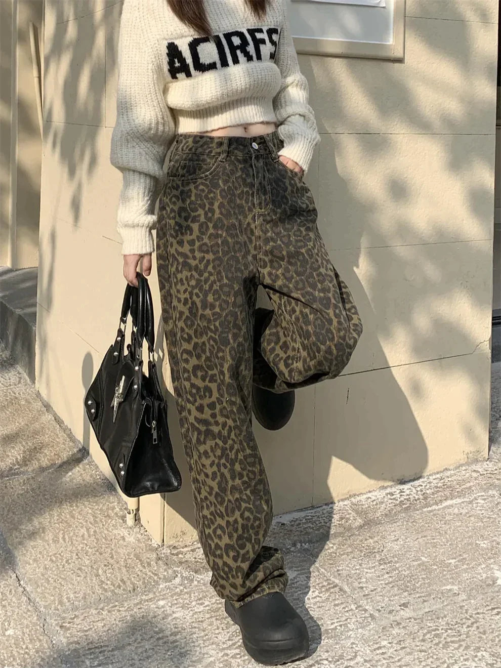 Close-up of trendy women's leopard print high-waisted jeans, showcasing bold animal print denim texture.