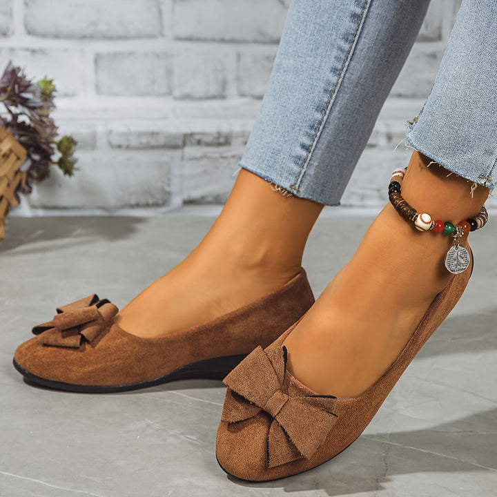 Chic white women's wedge flats, round toe, slip-on, bow detail, for versatile outfits.