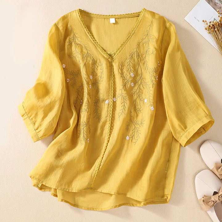 Elegant women's embroidered top with artistic detail, a breathable shirt for sophisticated summer wear.