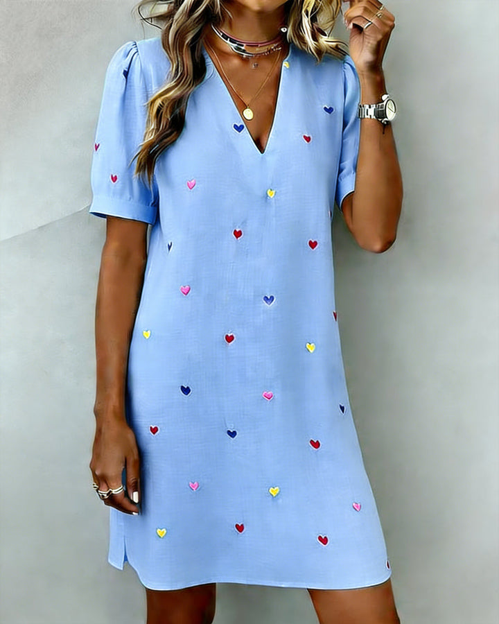 Feminine women's mini dress featuring a cute heart print, puff sleeves, and V-neck. Relaxed fit, great for casual elegance.