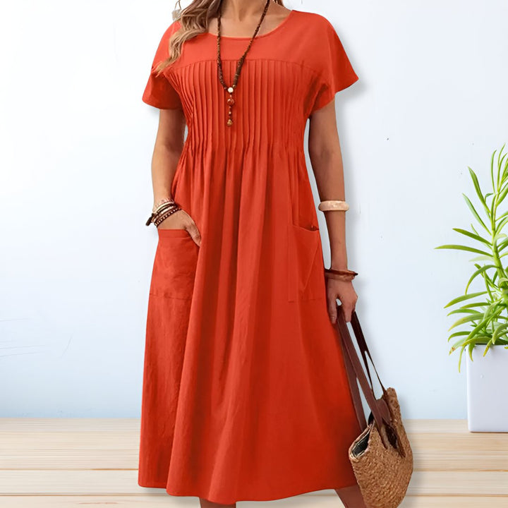 Comfortable women's relaxed midi dress featuring practical pockets, suitable for easy everyday wear.