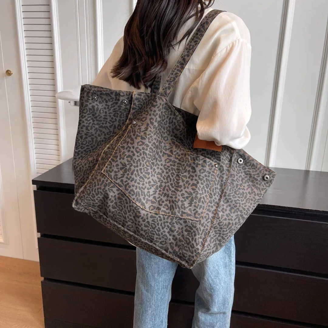 Luxury women's leopard print handbag, a chic black & brown animal print statement bag.