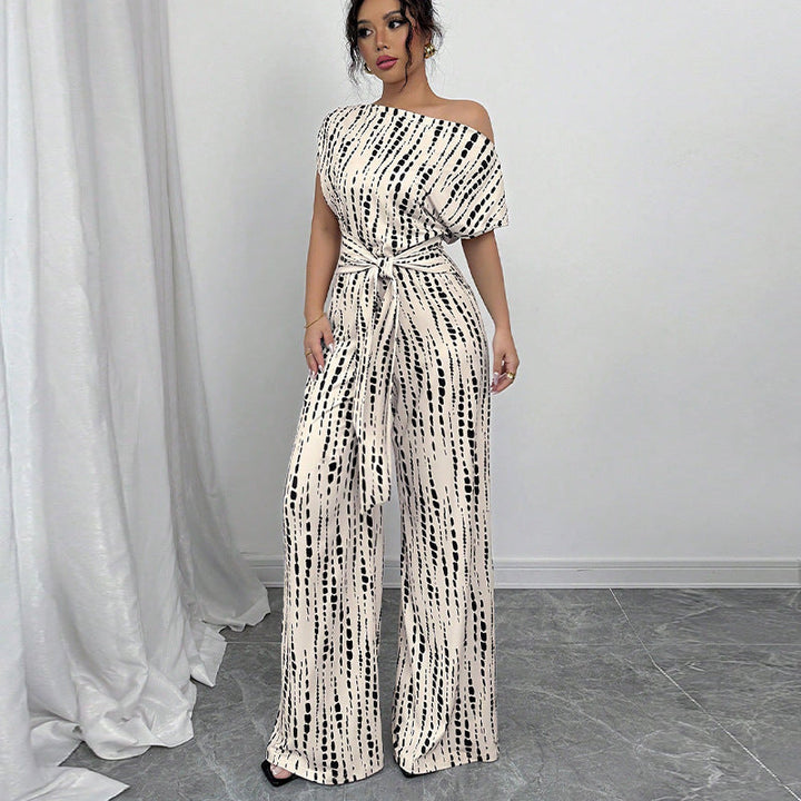 Women's chic printed wide leg jumpsuit with a stylish one-shoulder design & belted waist for an elegant party outfit.