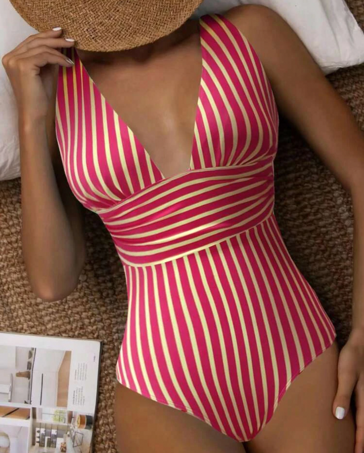Women's striped one-piece swimsuit on a model, showcasing stylish beachwear.