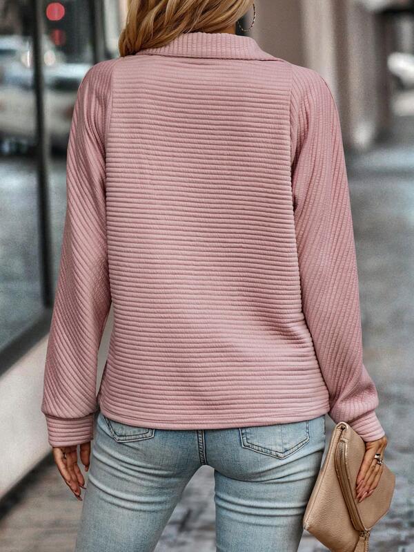 Close-up of a women's chic V-neck sweater with zipper detail, showcasing knit texture.
