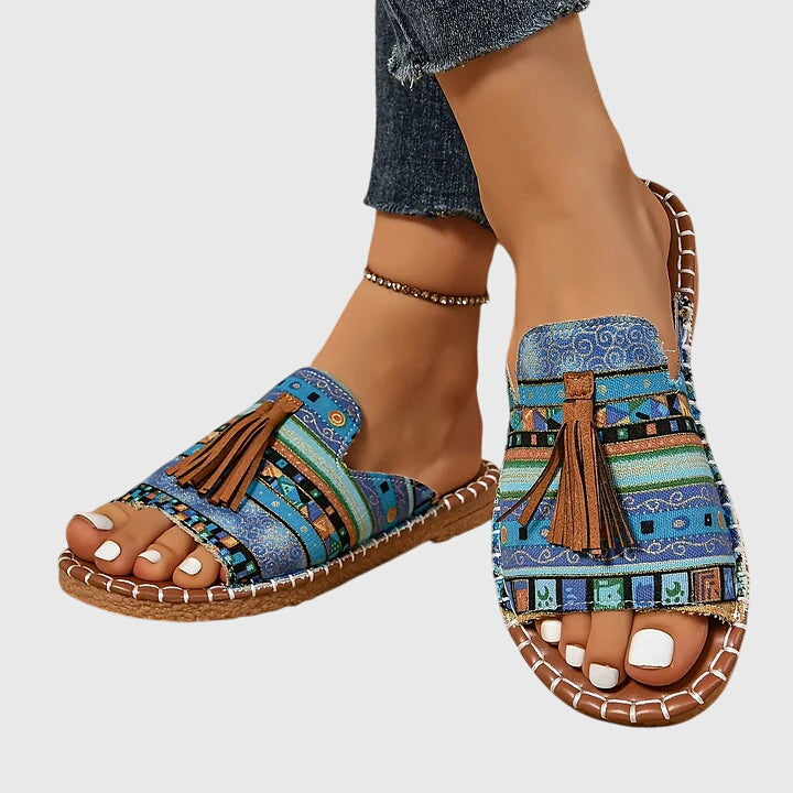 Comfortable women's slip-on sandals, ideal for everyday style & vacation, featuring tassel detail.