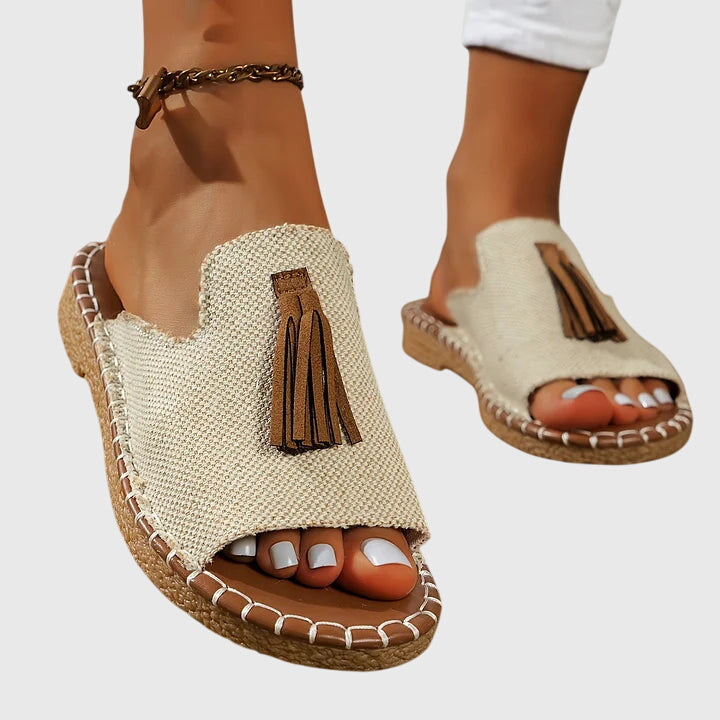 Open-toe women's casual sandals featuring elegant tassel straps & a comfortable slip-on design.