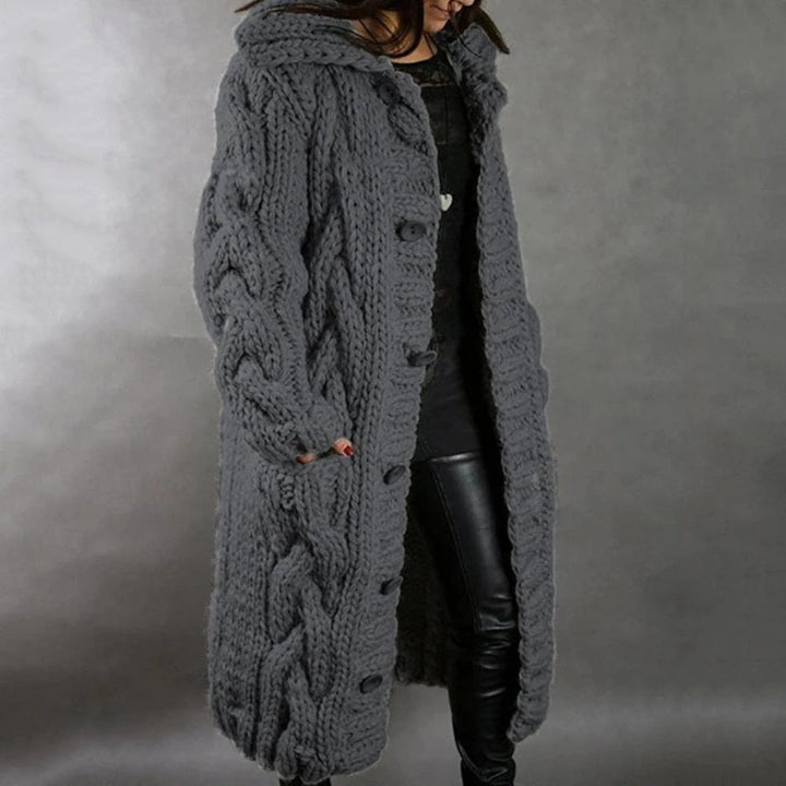 Warm women's cable knit maxi cardigan featuring a hood, cozy long knit outerwear for winter fashion.