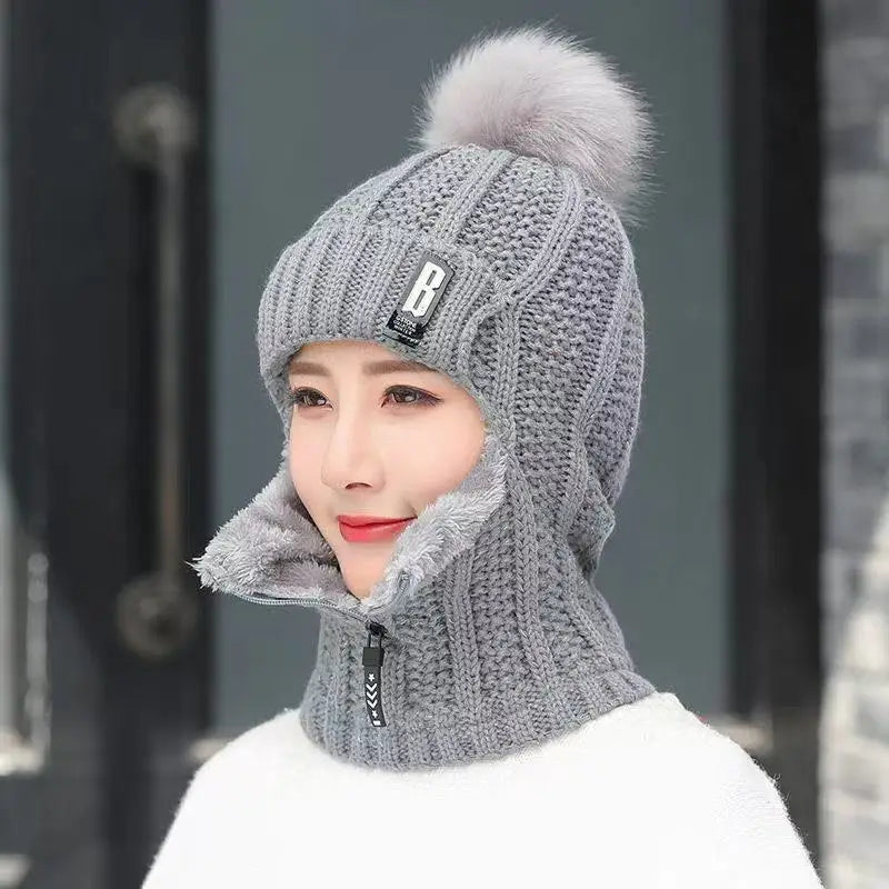 Fashionable women's knitted balaclava hat, a trendy winter accessory with pompom for stylish cold weather outfits.